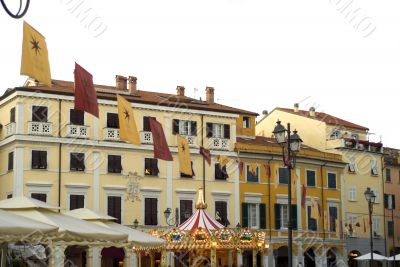 Sarzana - Buildings, flags and carousel