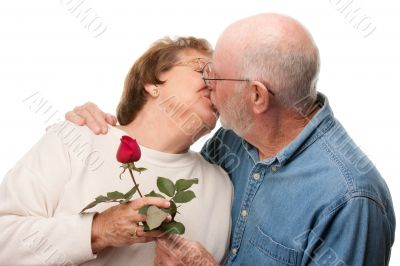 Happy Senior Couple Kissing with Red Rose
