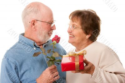 Happy Senior Couple with Gift and Red Rose