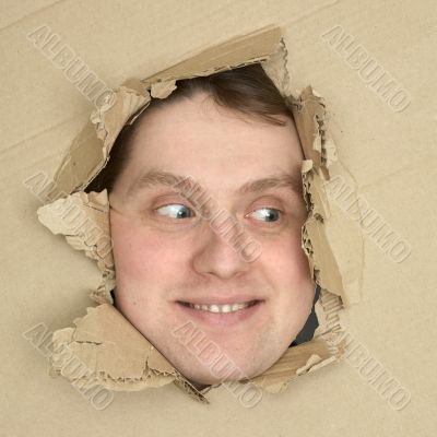 Male face look up from hole in carton