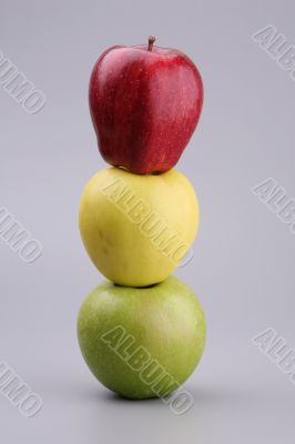 Three apples on a grey background