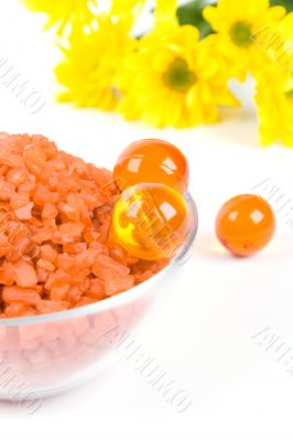 bath salt, oil balls in a bowl and yellow flowers