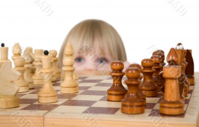 Little girl looking chess