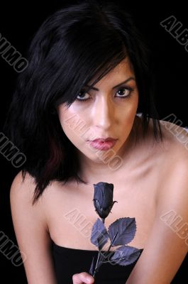 Beautiful young brunette woman with a black rose