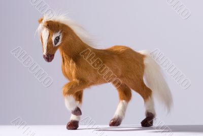 Friendly horse toy prancing on white