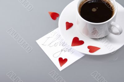 Cup with hot coffee, hearts and a note