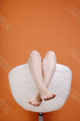 Female feet on an orange background