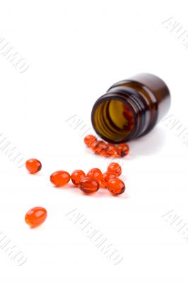 glass bottle with red pills