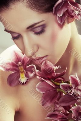 Beautiful young woman with orchid flowers