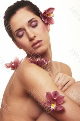 Beautiful young woman with orchid flowers