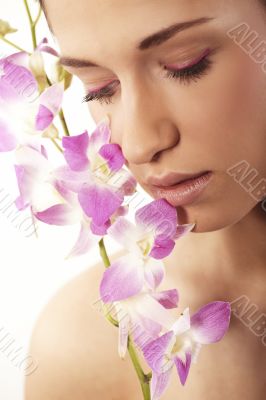 Beautiful young woman with orchid flowers