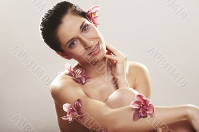 Beautiful young woman with orchid flowers