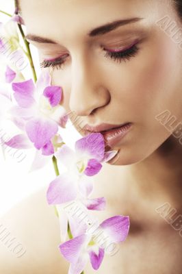 Beautiful young woman with orchid flowers