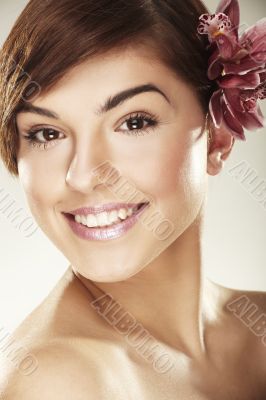Beautiful young woman with orchid flowers
