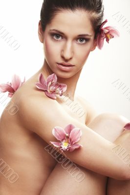 Beautiful young woman with orchid flowers