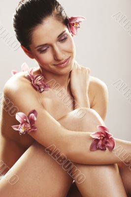 Beautiful young woman with orchid flowers