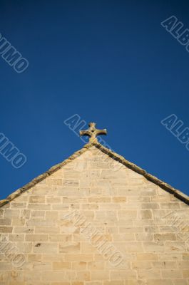 stone cross at top of church