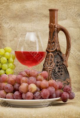 Ceramic bottle, grapes and red wine