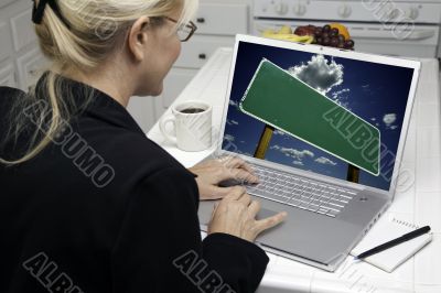Woman In Kitchen Using Laptop
