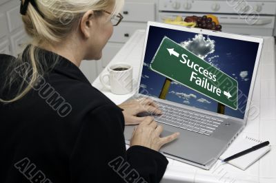 Woman In Kitchen Using Laptop