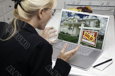 Excited Woman In Kitchen Using Laptop - Real Estate Success