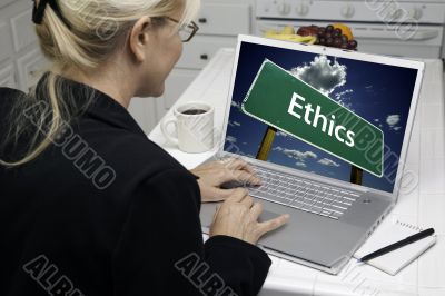 Woman In Kitchen Using Laptop