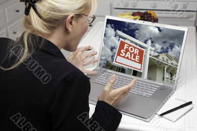 Excited Woman In Kitchen Using Laptop  - Real Estate Shopping