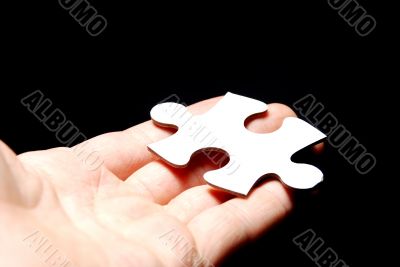 Hand holding a puzzle piece