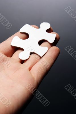 Hand holding a puzzle piece