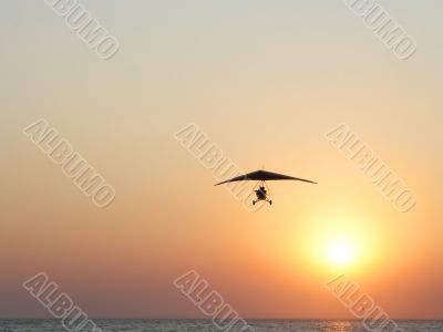Hangglider in action against a sea sunset