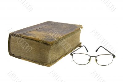 Glasses near very old bible on the white background