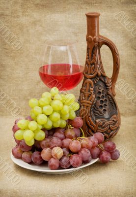 Ceramic bottle, grapes and red wine
