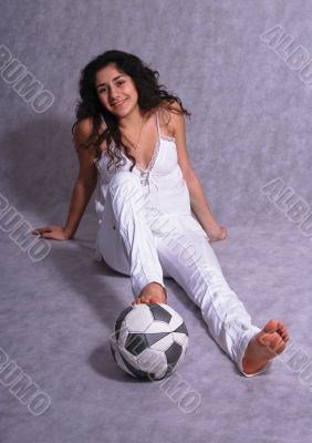 Beautiful girl sitting on a floor with a ball