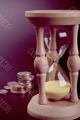 sand clock and coins