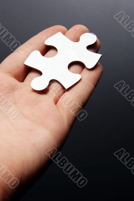 Hand holding a puzzle piece