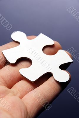 Hand holding a puzzle piece