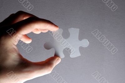 Hand holding a puzzle piece
