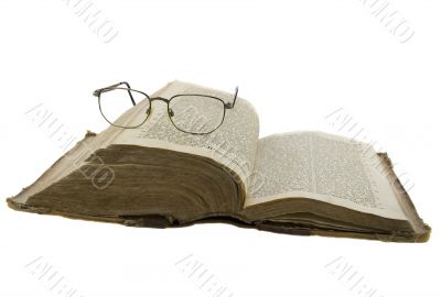 Vintage open book bible open and glasses on it isolated over whi