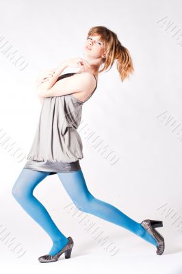 Teenager in blue pantyhose and grey blouse posing