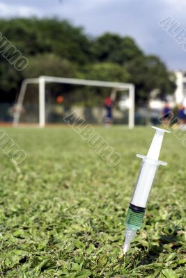 Soccer players at the field, syringe in foreground