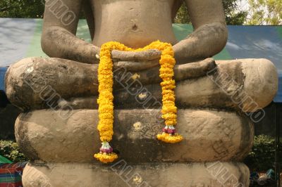 Sitting Buddha with yellow flowers in hands