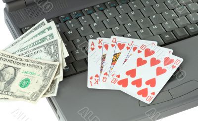 Laptop, playing cards and dollars
