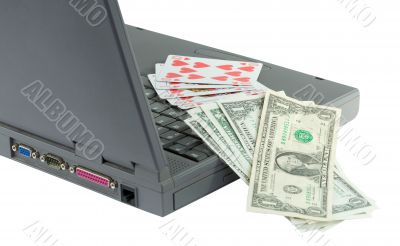 Laptop, playing cards and dollars