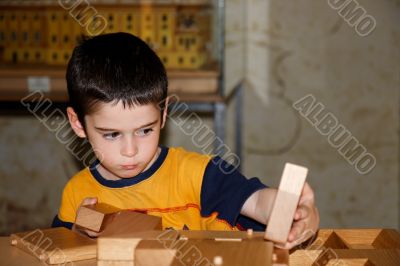Little boy plays with wooden bricks