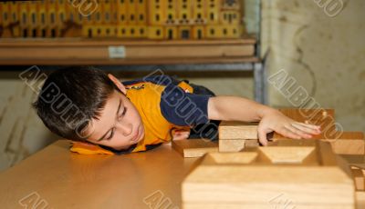 Little boy plays with wooden bricks