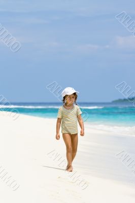 A young girl walking on the beach