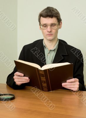 Guy in eyeglasses reads the book