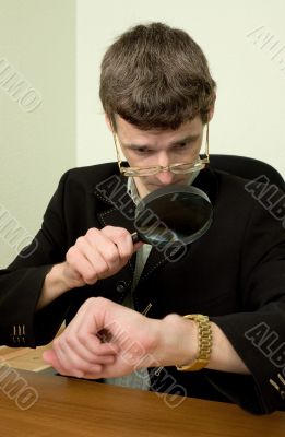 Person view a watch through a magnifier