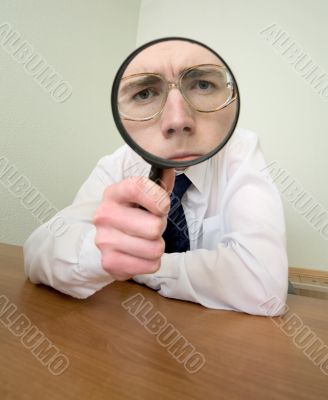 Man with a magnifier in a hand