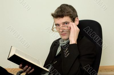 Guy in eyeglasses reads the book
